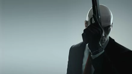 A striking HD desktop wallpaper featuring Agent 47 from the Hitman video game series, poised with a gun, embodying the sleek and mysterious allure of the 2016 release.