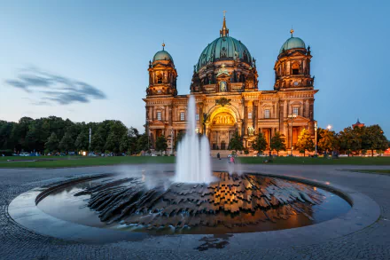 Night view of Berlin Cathedral in Germany illuminated behind a fountain, capturing the religious architecture in a serene, HD desktop wallpaper scene.
