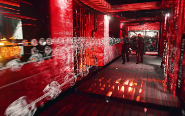 HD desktop wallpaper for Gemini: Heroes Reborn, featuring characters in a red-lit corridor with reflective surfaces and chain barriers.