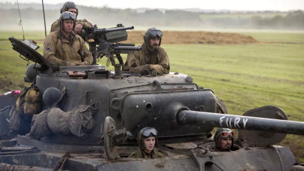 A gripping scene from the movie Fury, featuring Shia LaBeouf and Brad Pitt, showcases soldiers on a tank in a dramatic landscape, embodying the intensity of wartime action.