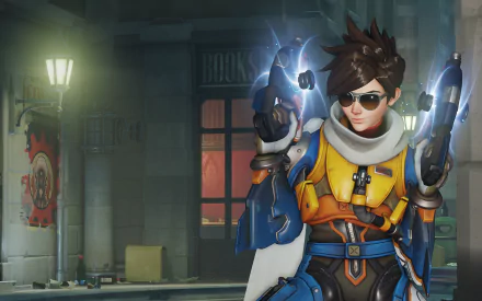 HD PC desktop wallpaper featuring Tracer from the video game Overwatch, depicted in her iconic outfit with dual pulse pistols in a dimly lit urban setting.