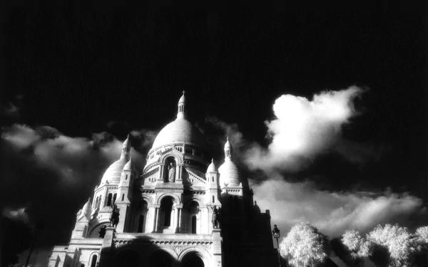 Black and white HD wallpaper of the Sacré-Cœur Basilica in Paris, France, set against dramatic clouds, showcasing the iconic religious monument.