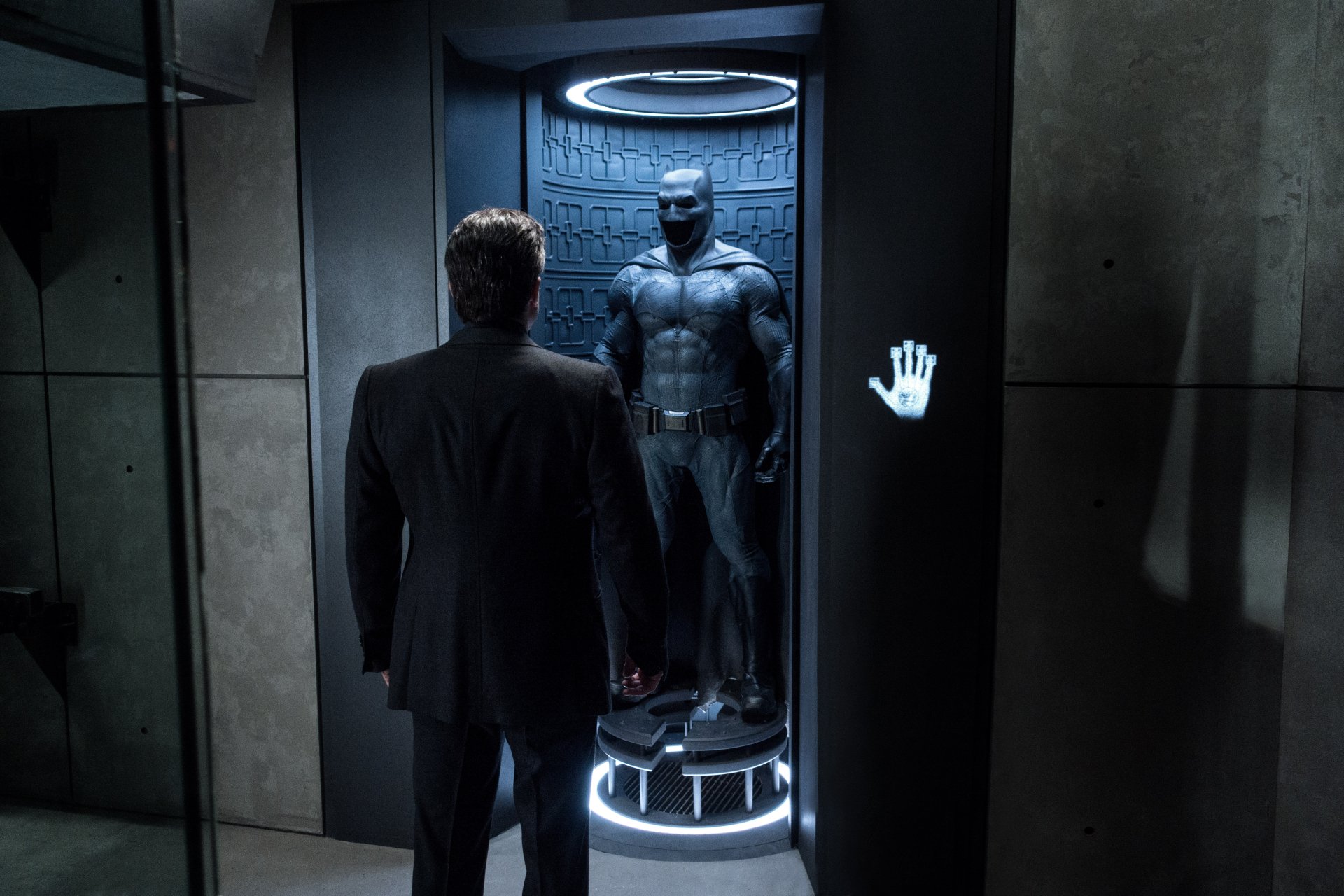 HD desktop wallpaper featuring Ben Affleck in Batman V Superman: Dawn Of Justice, showing Bruce Wayne standing before the Batman suit in a dimly lit chamber.