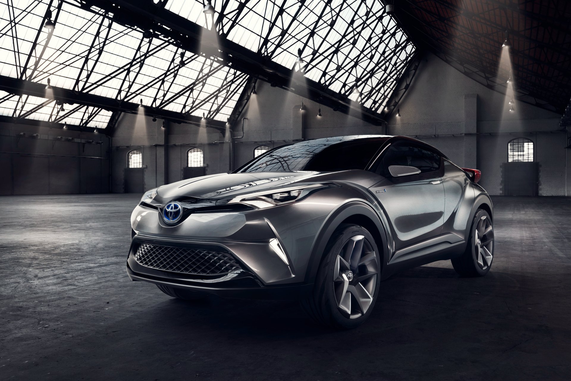 Silver Toyota C-HR concept SUV car in a dramatic industrial hangar, rendered as a high-detail 4K Ultra HD PC desktop wallpaper and background.
