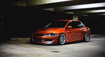 HD desktop wallpaper featuring a sleek orange JDM car parked in a dimly lit garage, exuding a cool urban vibe.