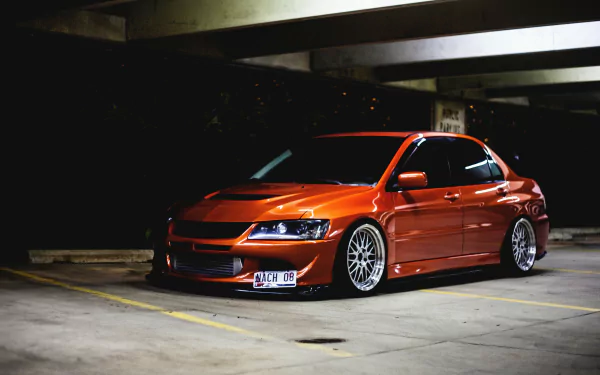 HD desktop wallpaper featuring a sleek orange JDM car parked in a dimly lit garage, exuding a cool urban vibe.