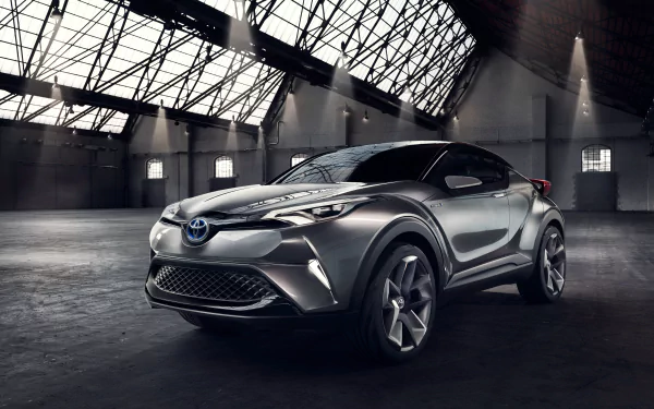Silver Toyota C-HR concept SUV car in a dramatic industrial hangar, rendered as a high-detail 4K Ultra HD PC desktop wallpaper and background.