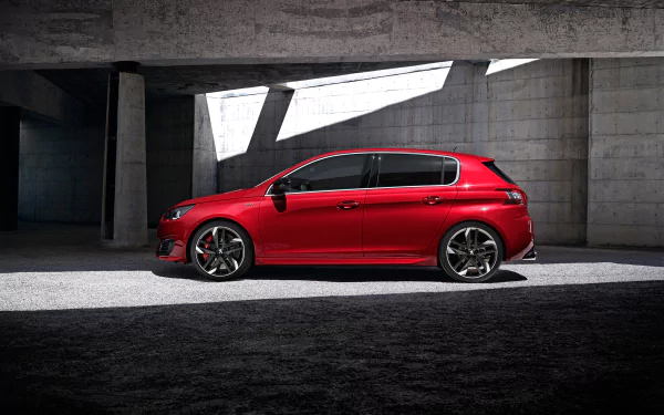 Red Peugeot 308 compact car in a concrete modern garage, captured as a 2K Quad HD PC desktop wallpaper background.