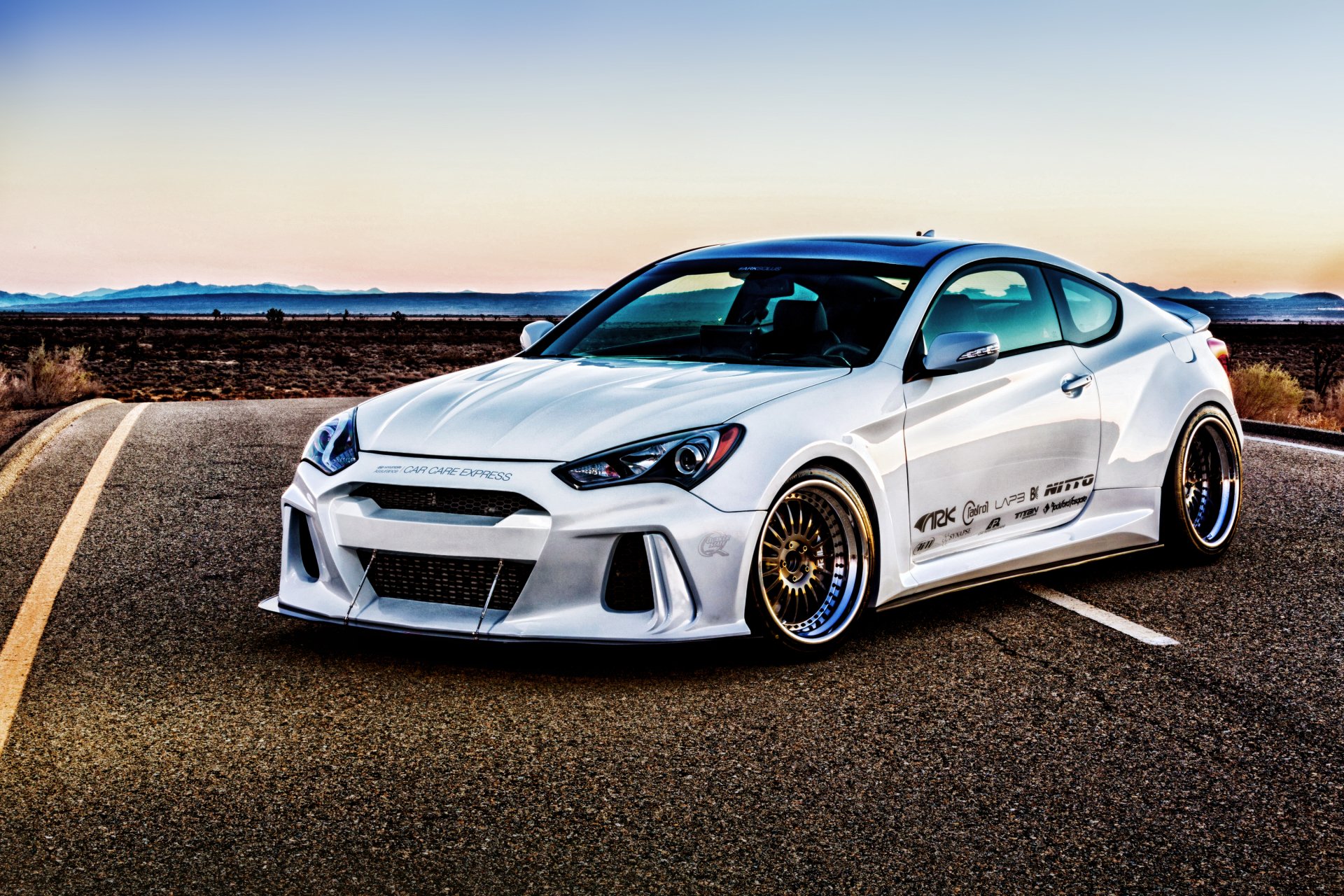 White Hyundai Genesis Coupe with custom body kit and gold mesh wheels parked on an open road at sunset — 2K Quad HD PC desktop wallpaper/background.