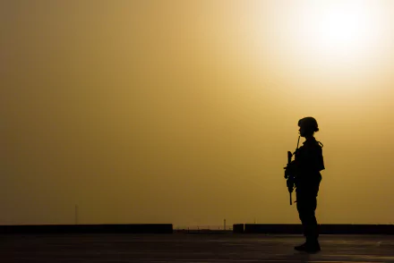 Silhouette of a soldier holding a weapon against a golden sky, captured in HD for a striking military-themed desktop wallpaper.
