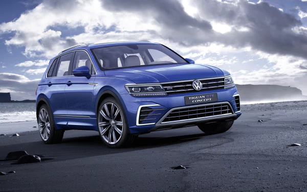 A blue Volkswagen Tiguan SUV parked on a rocky shore under a cloudy sky, captured in 4K Ultra HD as a PC desktop wallpaper.