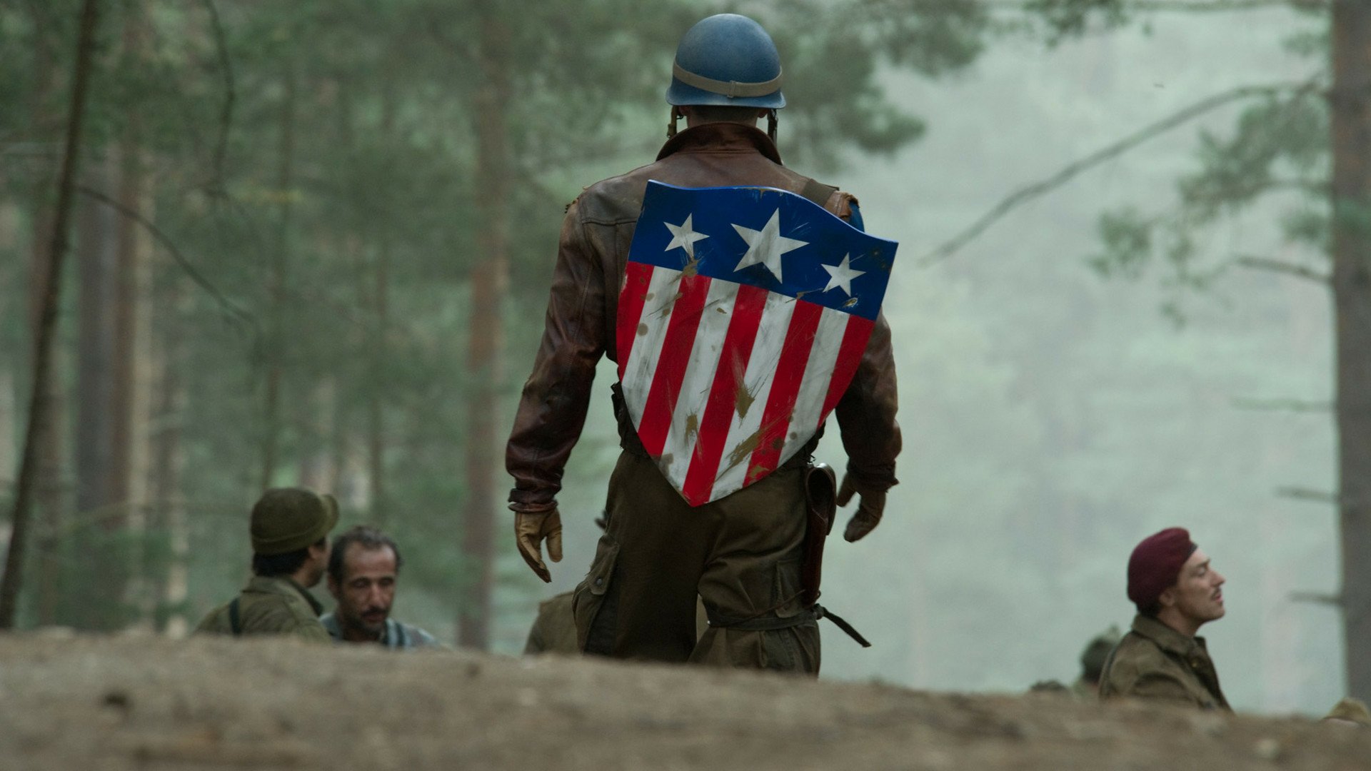 HD PC desktop wallpaper featuring Captain America from the movie Captain America: The First Avenger, showing him with his iconic shield on his back in a forest setting.