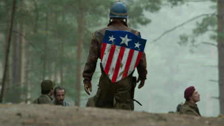 HD PC desktop wallpaper featuring Captain America from the movie Captain America: The First Avenger, showing him with his iconic shield on his back in a forest setting.