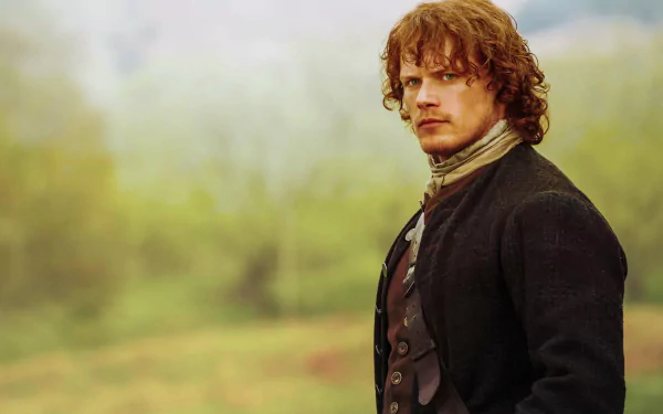 Jamie Fraser, portrayed by Sam Heughan in the TV show Outlander, stands confidently in a lush, green landscape, capturing the essence of his character in this HD desktop wallpaper.