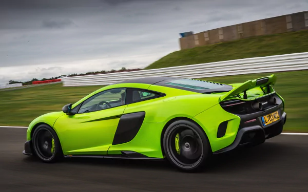 A vibrant green McLaren 675LT supercar speeds along a race track under a cloudy sky, captured in stunning 4K Ultra HD as a dynamic PC desktop wallpaper.
