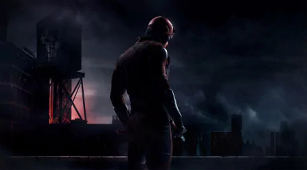 A dramatic HD wallpaper featuring Daredevil, standing on a rooftop against a dark, moody cityscape, embodying his vigilant presence in the night.