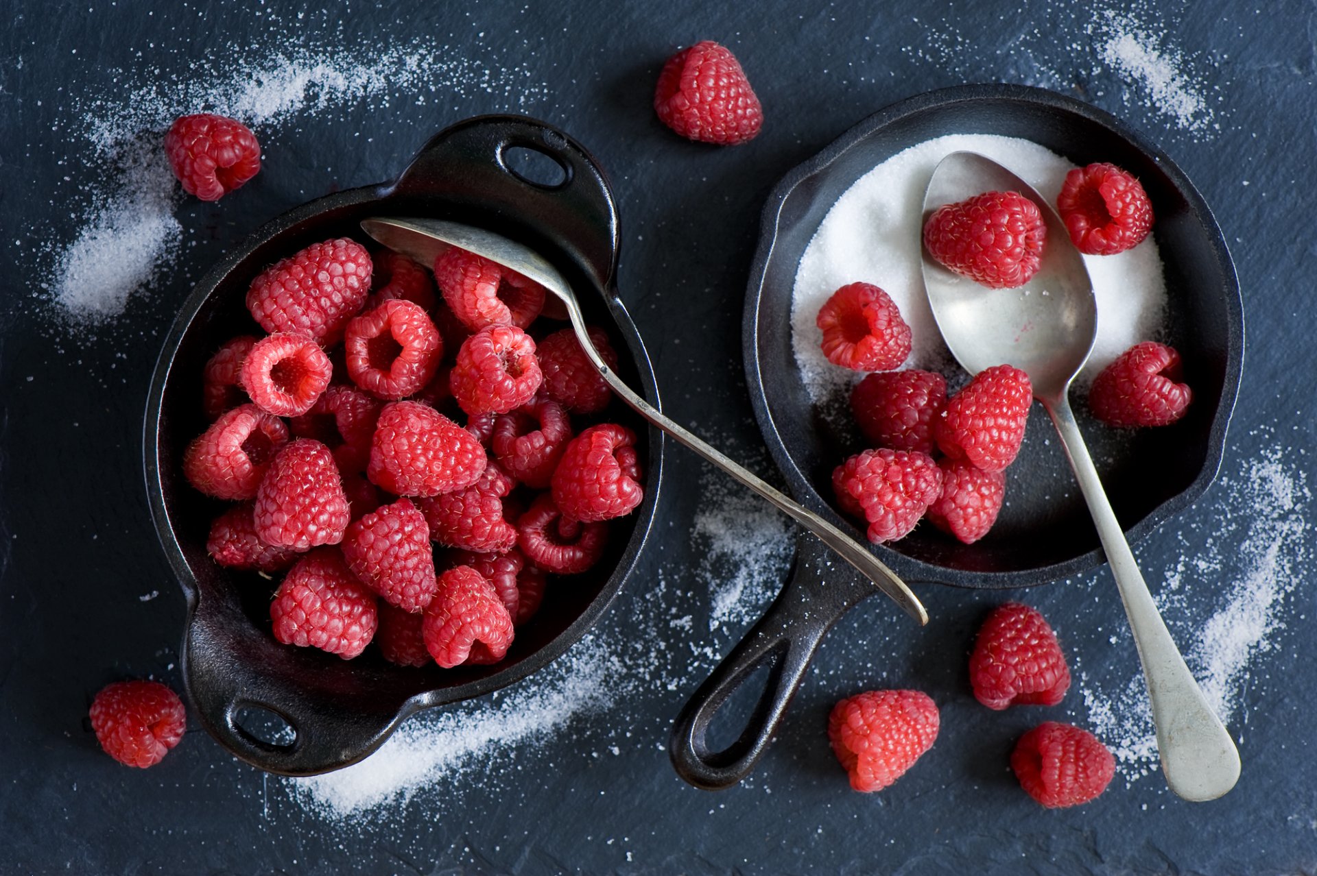 Close-up still life of fresh raspberries with granulated sugar on a dark surface, captured in HD for a vivid PC desktop wallpaper and background.