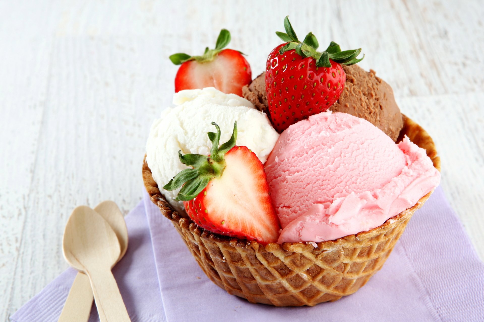 A vibrant 4K Ultra HD desktop wallpaper featuring a waffle bowl filled with strawberry, chocolate, and vanilla ice cream scoops, topped with fresh summer strawberries on a lavender cloth.