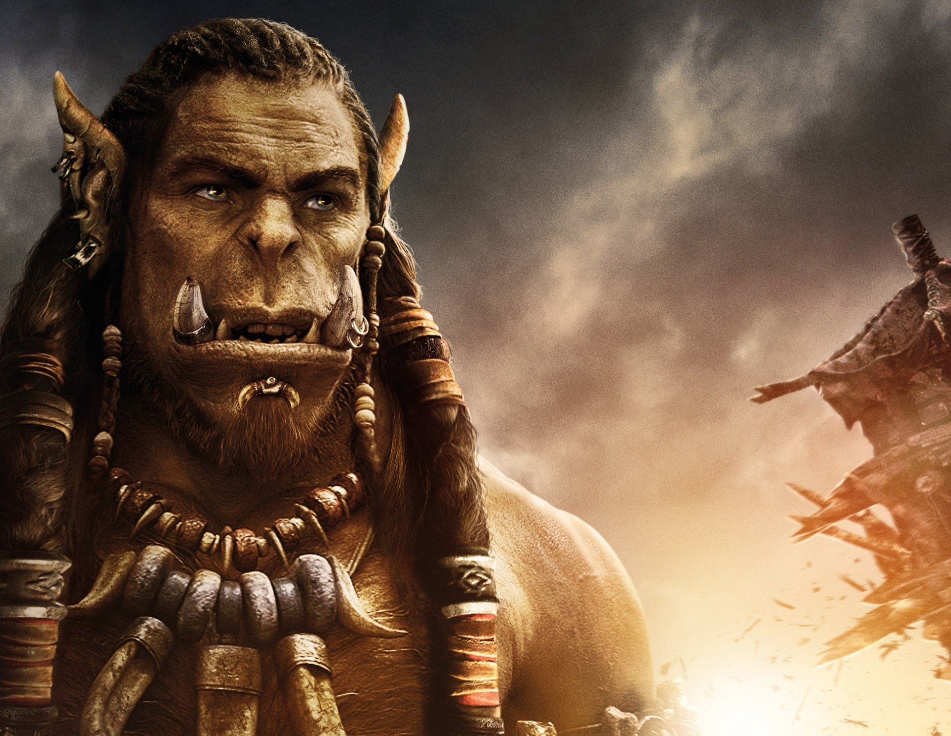 HD PC desktop wallpaper featuring a close-up of an orc character from the Warcraft movie against a stormy sky background.