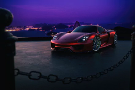 Sleek red Porsche 918 Spyder supercar parked at night with city lights in the background, captured in HD desktop wallpaper quality.
