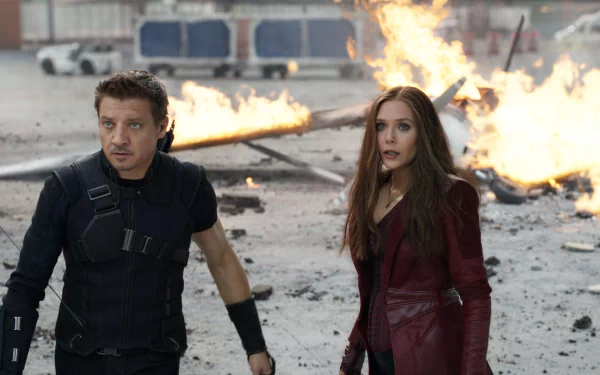 Elizabeth Olsen and Jeremy Renner portray Scarlet Witch and Hawkeye in a dramatic scene from Captain America: Civil War, set against a fiery backdrop. High-definition wallpaper.