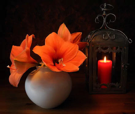 A vibrant orange lily blooms beside a glowing candle in an ornate lantern, all set within a minimalist vase, creating a warm, inviting still life arrangement in this HD desktop wallpaper.