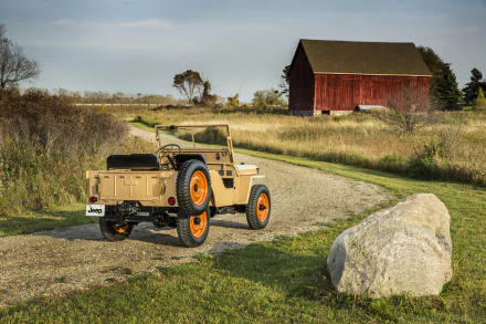 4K Ultra HD image of a classic Willys MB military Jeep parked on a rural dirt road with a red barn and open fields in the background.