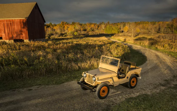 4K Ultra HD desktop wallpaper featuring a classic military Willys MB Jeep on a winding dirt road near a red barn under a dramatic sky.