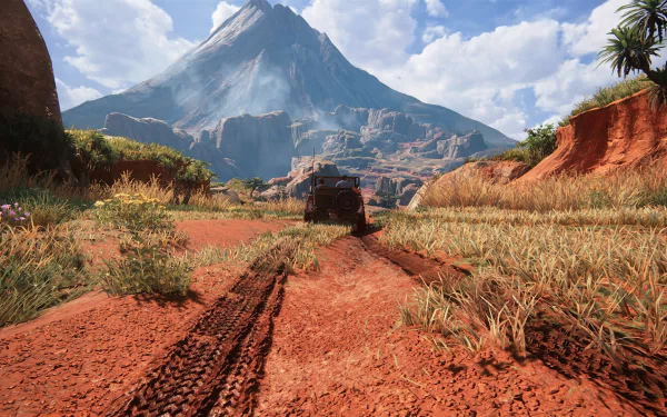 HD PC desktop wallpaper from the video game Uncharted 4: A Thief's End, featuring a rugged dirt road leading to a mountainous landscape under a bright, partly cloudy sky.