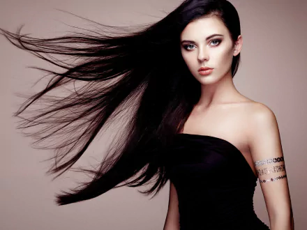 HD PC desktop wallpaper of a black-haired model with long hair flowing sideways, wearing a strapless black top against a soft neutral background.