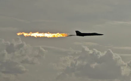 HD PC desktop wallpaper: military General Dynamics F-111 Aardvark in flight, afterburner blazing against a cloudy sky.