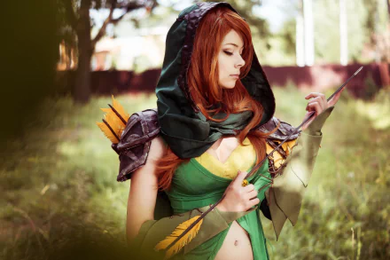 A cosplayer brilliantly embodies Windranger from DotA 2, standing outdoors with a serene expression, detailed in green and yellow costume with a quiver of arrows. HD wallpaper for desktop.