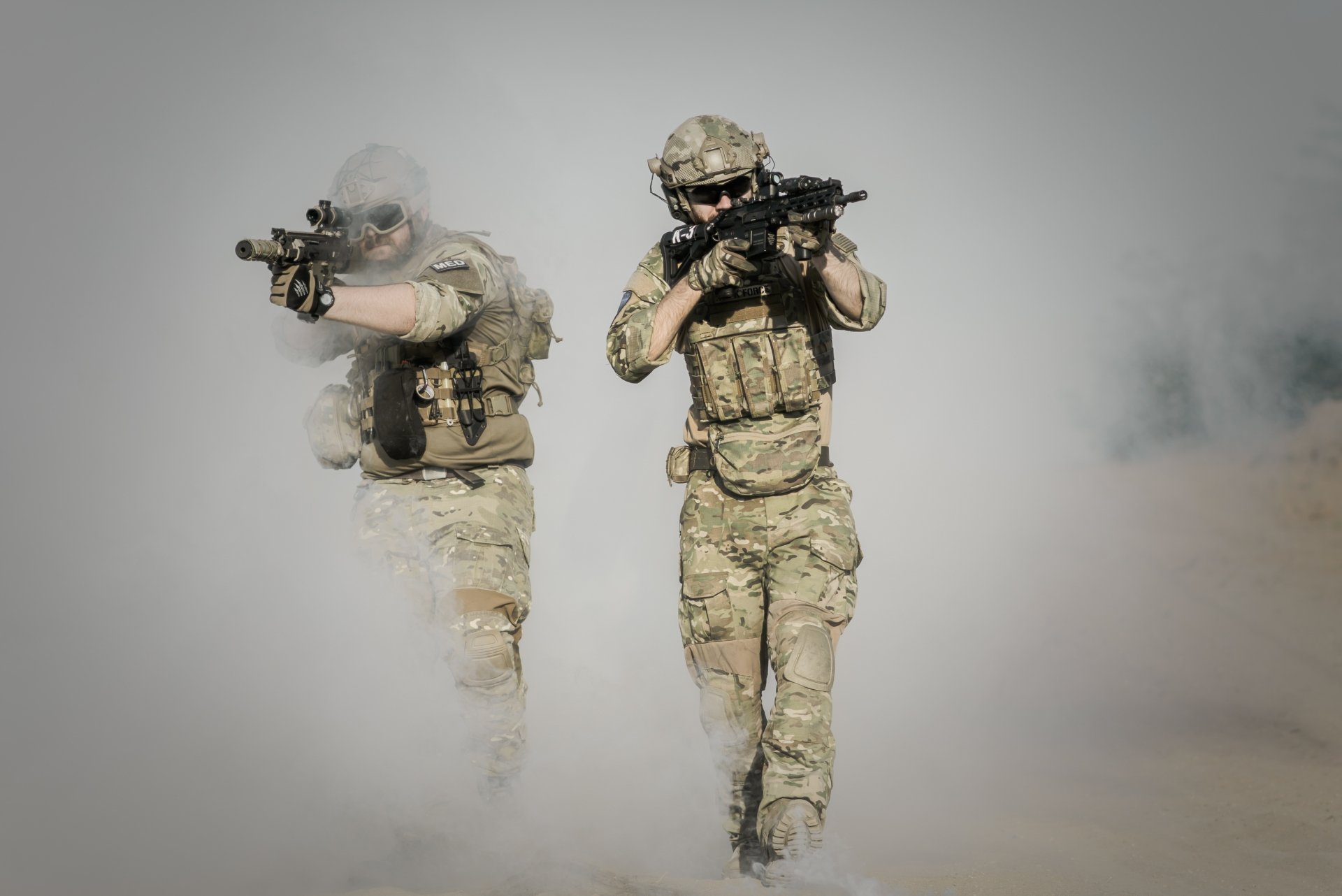 HD desktop wallpaper showing two soldiers in camouflage gear and rifles advancing through thick smoke, captured in a detailed cosplay scene.