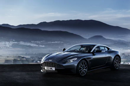 A sleek black Aston Martin DB11 supercar is parked against a scenic mountain backdrop, with a cat resting nearby, creating a striking 4K Ultra HD visual experience.