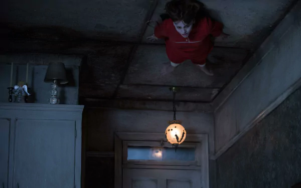A chilling scene from The Conjuring 2, featuring Sterling Jerins in a haunting room, adds an eerie touch to this HD desktop wallpaper.