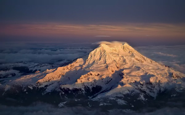 Snow-covered mountain bathed in golden light at sunset, showcasing stunning natural beauty in this HD PC desktop wallpaper and background.