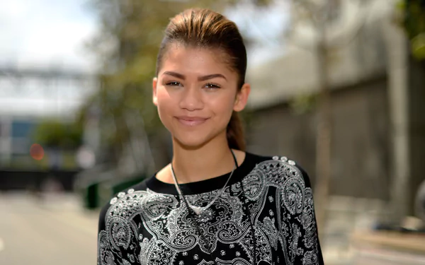 Portrait of American singer and actress Zendaya with brown eyes and brunette hair, smiling outdoors in a sharp 4K Ultra HD wallpaper quality image.