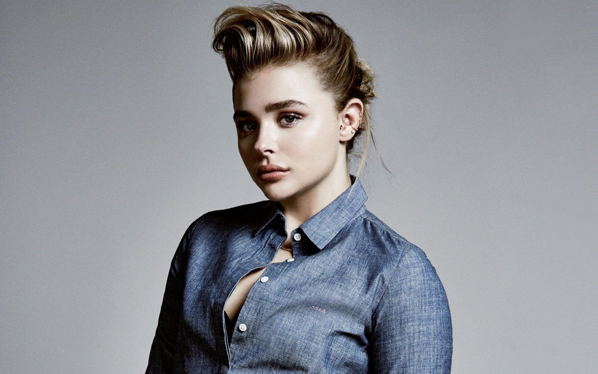 Chloë Grace Moretz poses confidently in a denim shirt, showcasing a stylish look in this HD desktop wallpaper and background, capturing her celebrity presence.