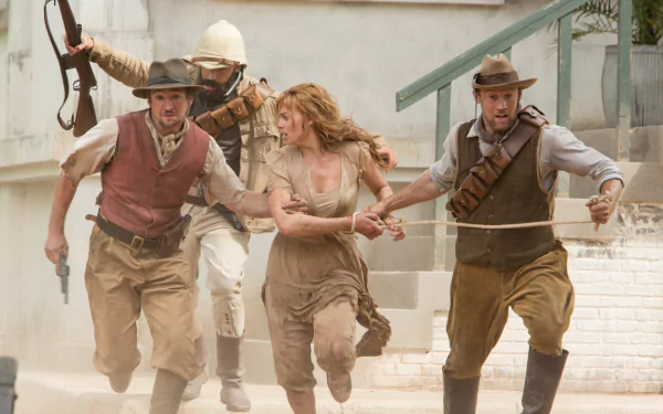 5K Ultra HD PC desktop wallpaper: action shot from The Legend of Tarzan movie — a period-dressed woman grabbed by two men in a dusty street as a soldier raises his rifle behind them.