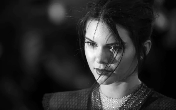 A striking black and white portrait of American model and celebrity Kendall Jenner, showcasing her intense gaze and elegant features against a softly blurred background.
