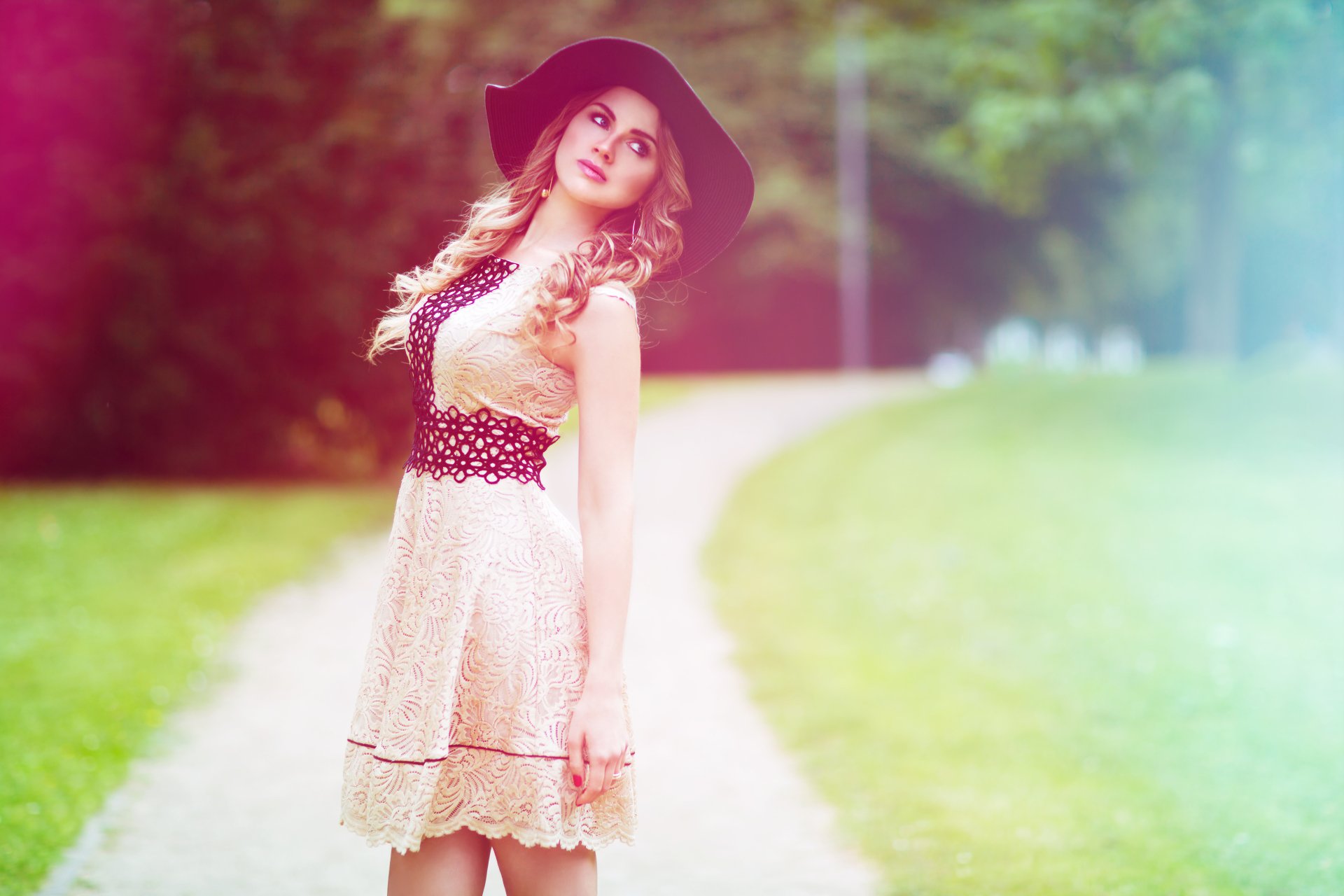 A blonde woman with blue eyes and a hat poses outdoors. She is styled as a model, creating a picturesque HD desktop wallpaper and background.