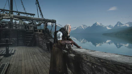 Geralt of Rivia from The Witcher cosplay: white-haired man in armor leaning on a ship railing, looking over a calm fjord and snow-capped mountains — HD PC desktop wallpaper/background.