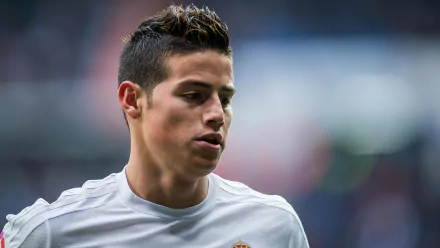 James Rodriguez in a Real Madrid C.F. uniform, captured in a dynamic moment, showcasing his focus and dedication on the field. A vibrant 4K Ultra HD wallpaper for sports enthusiasts.