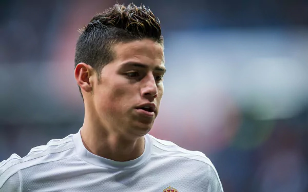 James Rodriguez in a Real Madrid C.F. uniform, captured in a dynamic moment, showcasing his focus and dedication on the field. A vibrant 4K Ultra HD wallpaper for sports enthusiasts.