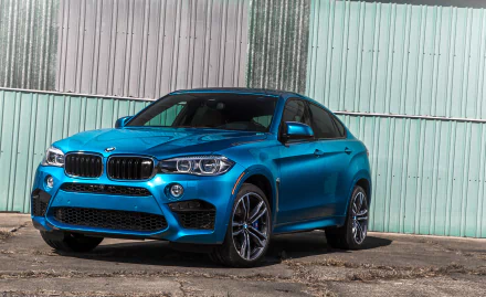 A blue BMW X6 SUV parked in front of a corrugated metal wall, captured in high definition as a PC desktop wallpaper and background.