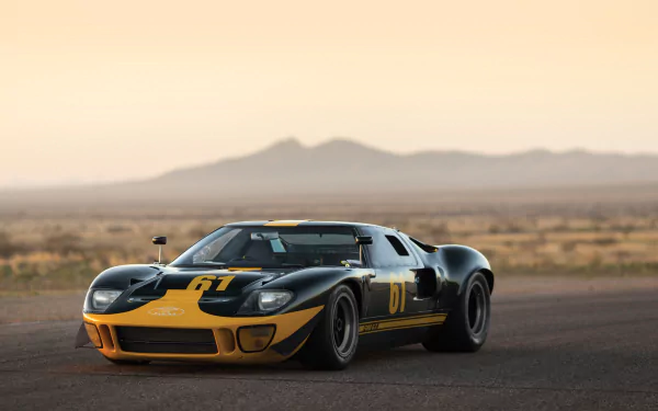 Black Ford GT40 Le Mans supercar with yellow accents, parked on a desert road at sunset, showcased in 4K Ultra HD for PC desktop wallpaper.