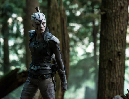 Jaylah, portrayed by Sofia Boutella in Star Trek Beyond, stands ready in a forest setting, featured in this 4K Ultra HD movie wallpaper and desktop background.
