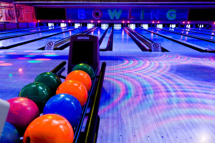 4K Ultra HD PC desktop wallpaper of a vibrant bowling alley with colorful bowling balls lined up, illuminated lanes, and a glowing BOWLING sign in the background.