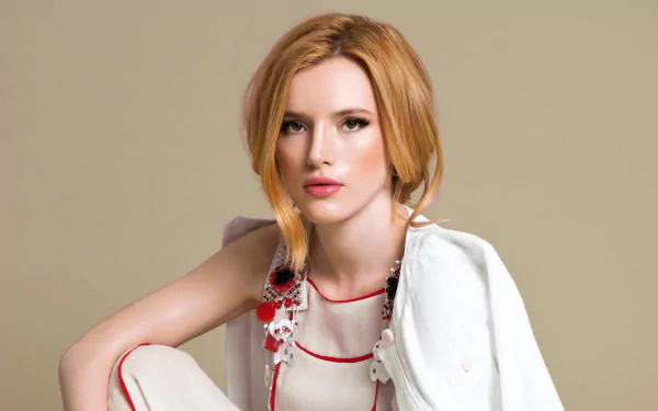 A striking HD wallpaper featuring American model and actress Bella Thorne, showcasing her brown eyes and red hair against a neutral background.