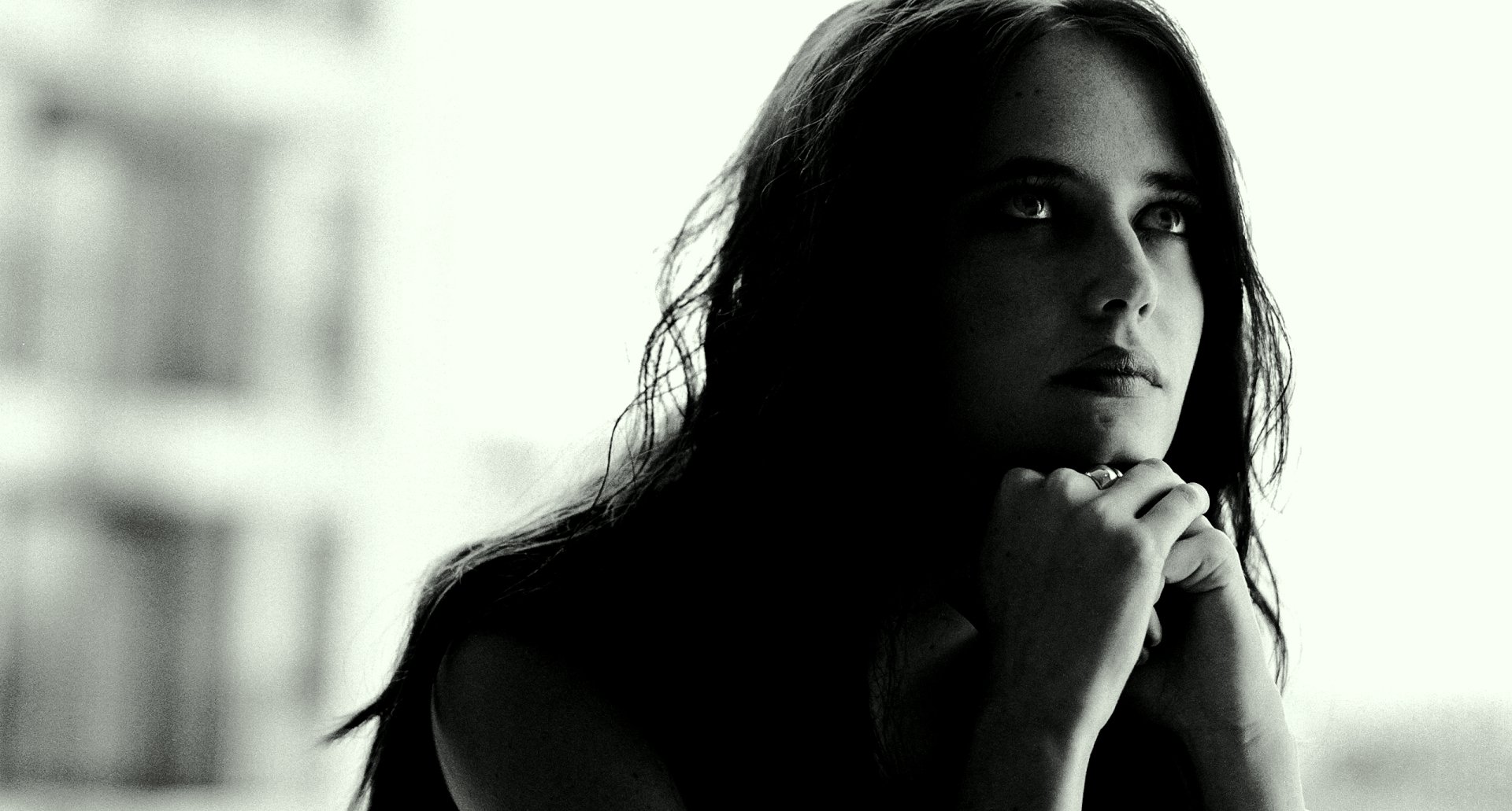 Black and white HD desktop wallpaper featuring a contemplative portrait of celebrity Eva Green with soft lighting and a blurred background.